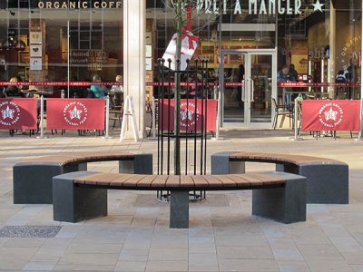 以普通堤道,彼得伯勒开发的圆形座位布置的定制木材和花岗岩长凳